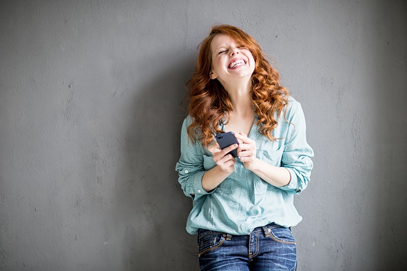 young lady with cell phone smilng
